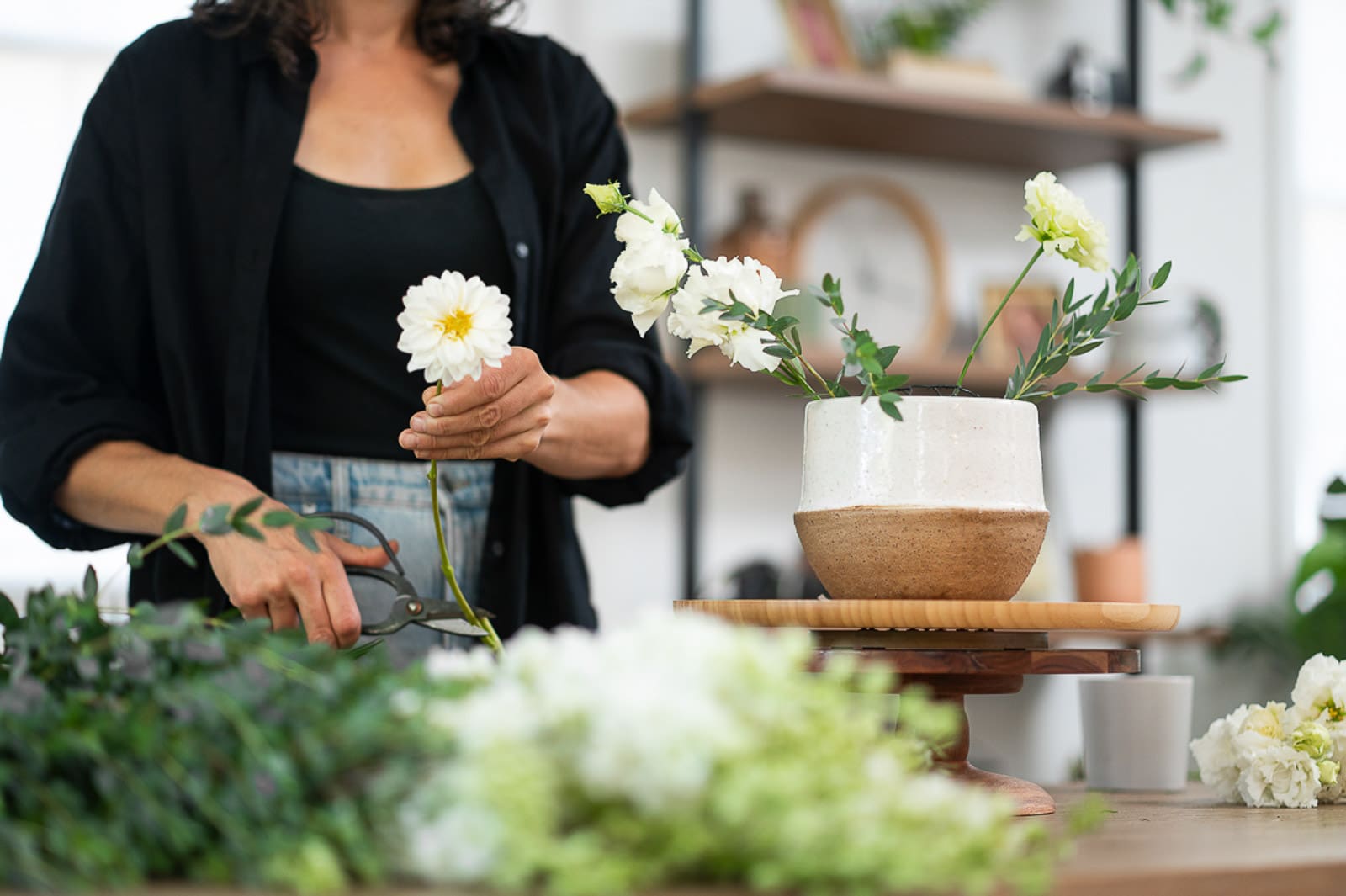 woman cutting flowers for an arrangement during a brand photography session
